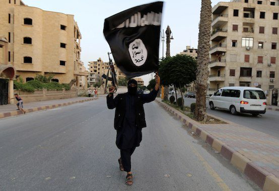 A member loyal to the ISIL waves an ISIL flag in Raqqa