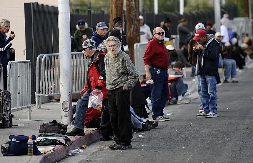 Homeless people wait to get food donatio
