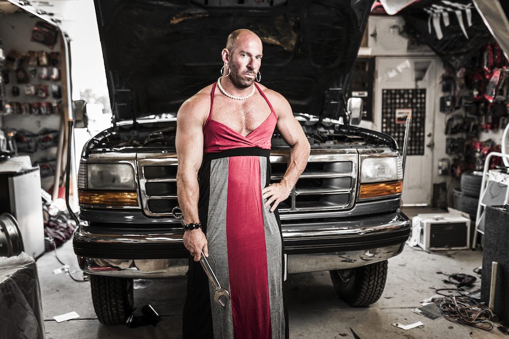 A man in a dress repairing a truck