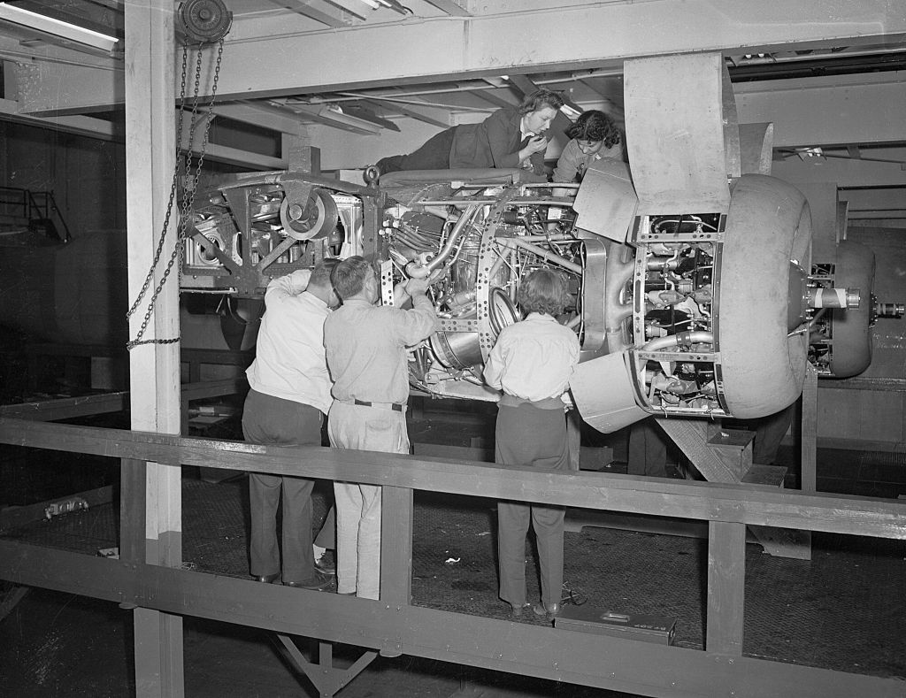 Workmen Fitting a Motor into a Bomber Plane