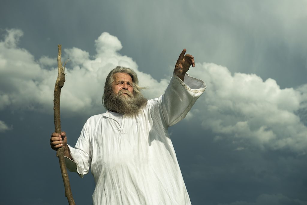 long-haired prophet pointing in front of dramatic sky