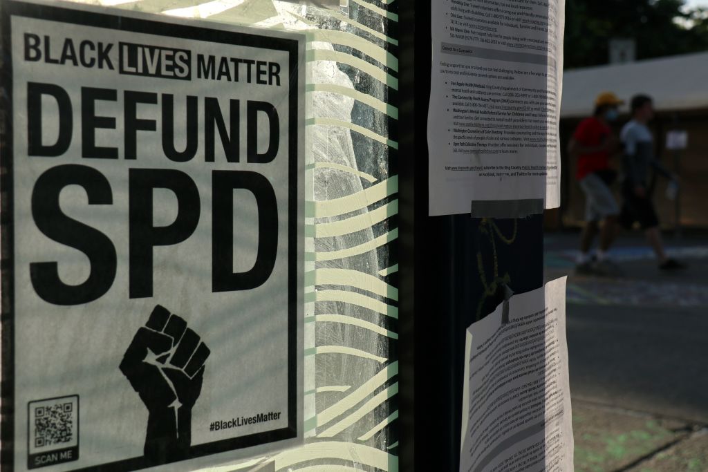 A sign is seen plastered to the side of a bus stop in