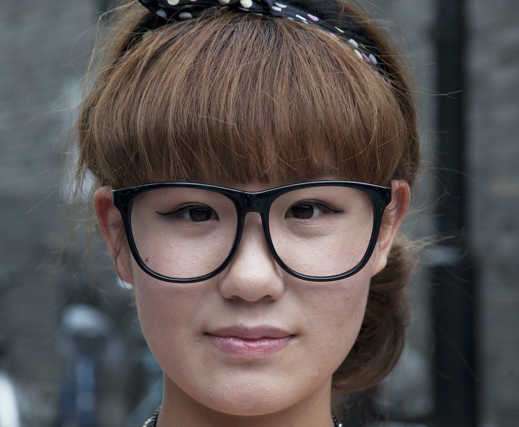 China - Beijing - Yandai Xiejie Hutong street model with no lenses in her glasses