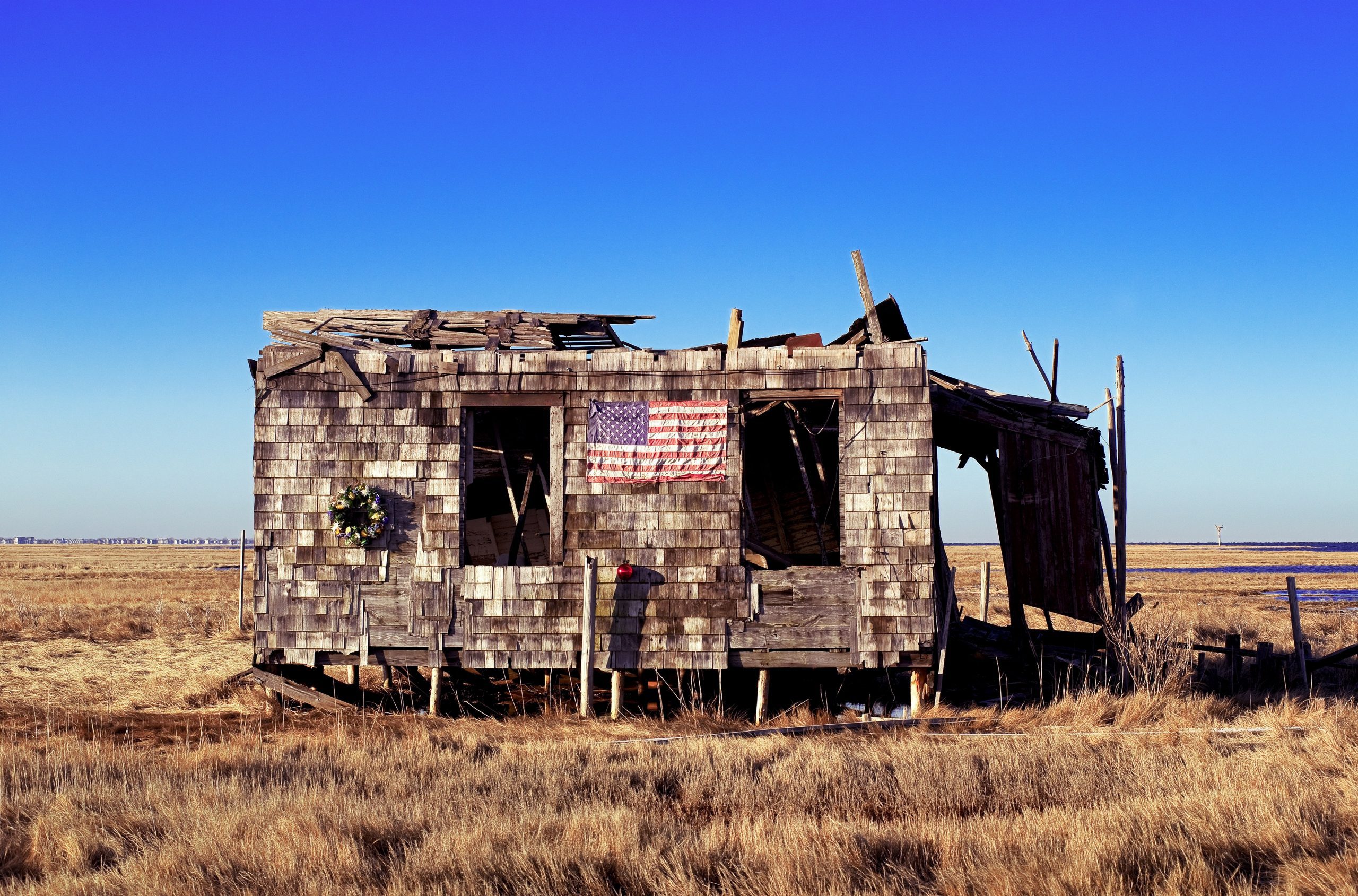 Ruined and abondoned shack with American flag and Christmas