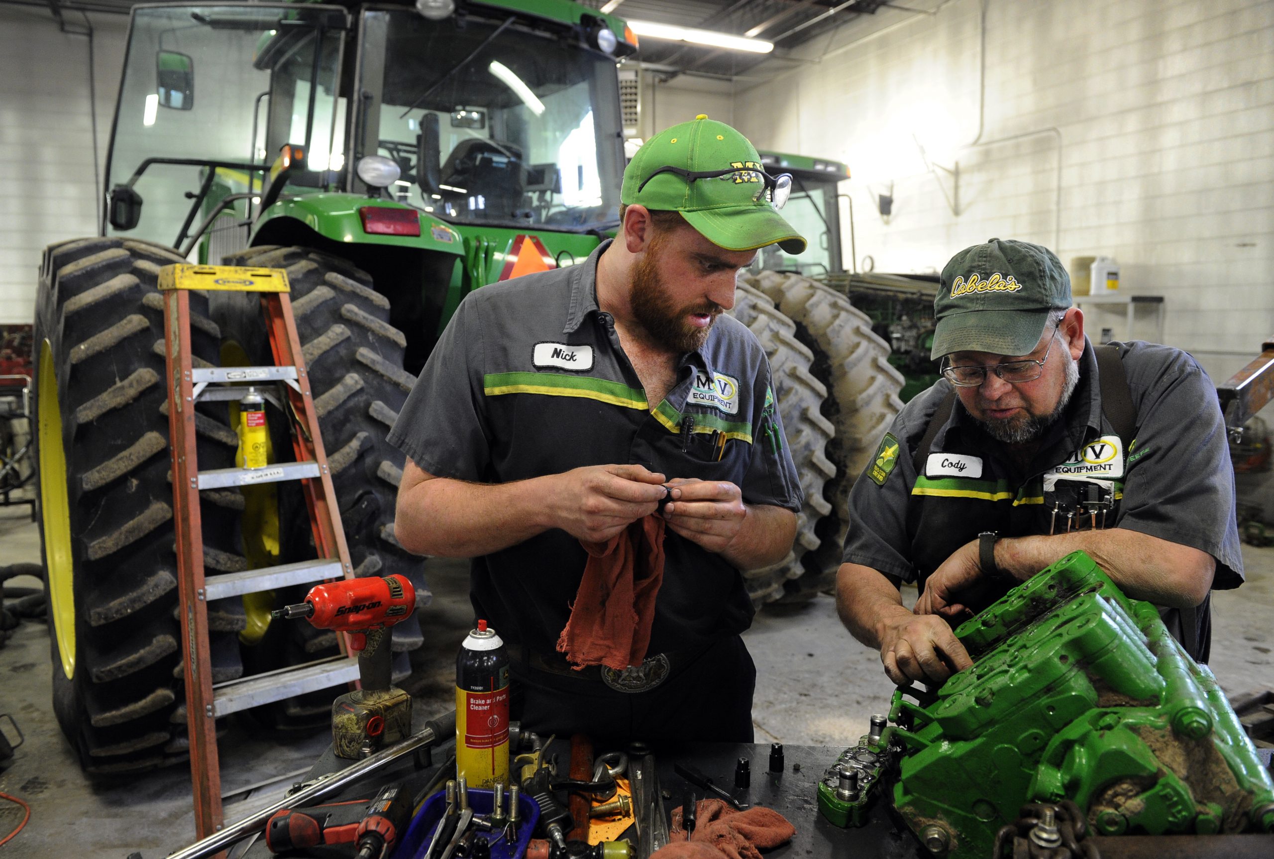 Master service tech/master mechanic for MV Equipment in Sterling Colorado, Cody Craven, right, works with service tech., Nick Anderson, left, working a repair a SCV stack on a John Deere 8320 tractor Tuesday afternoon, February 28th, 2012. Andy Cross, The