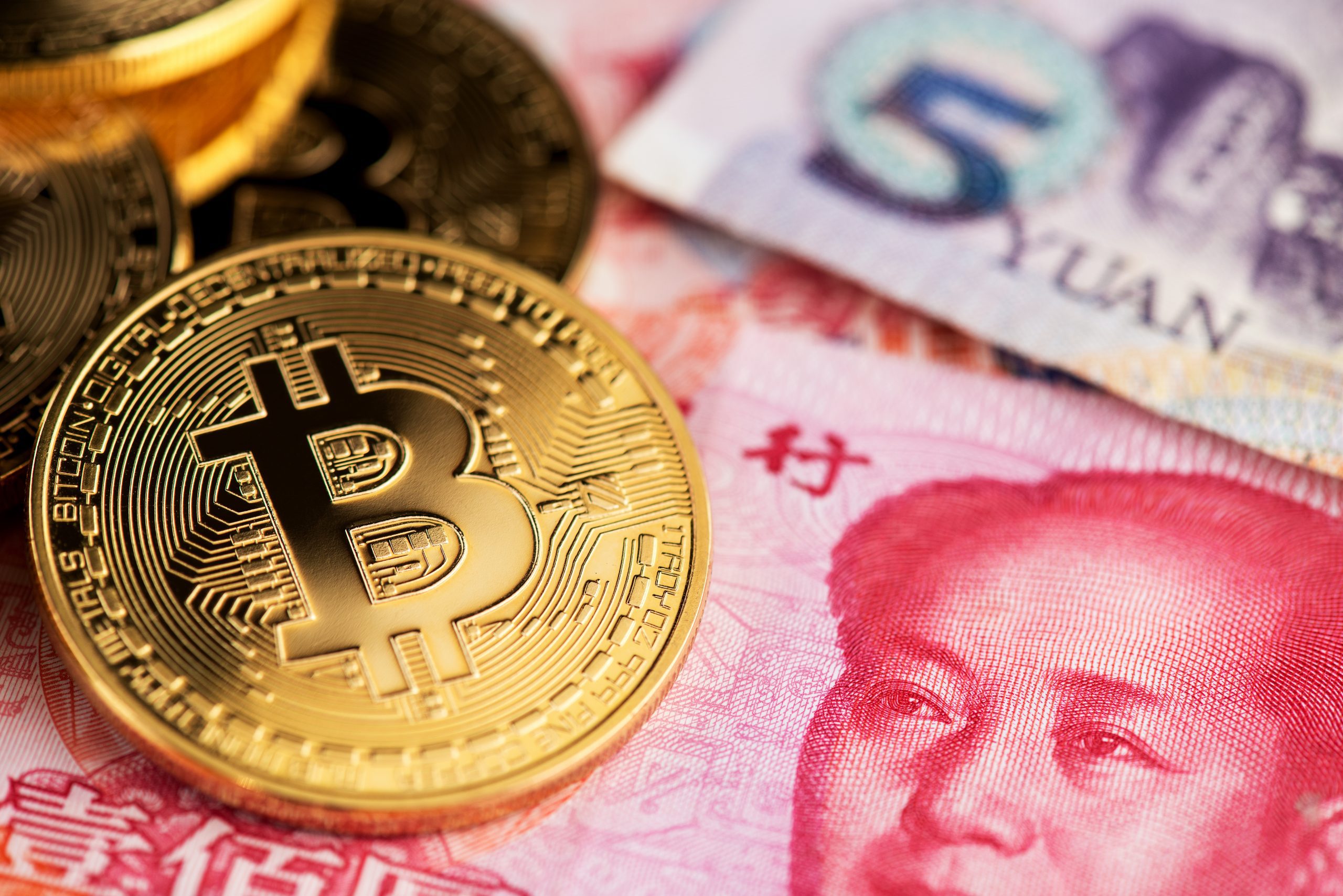 Background,With,Bitcoin,Cryptocurrency,Coins,And,China,Yuan,Banknotes.,Bitcoin