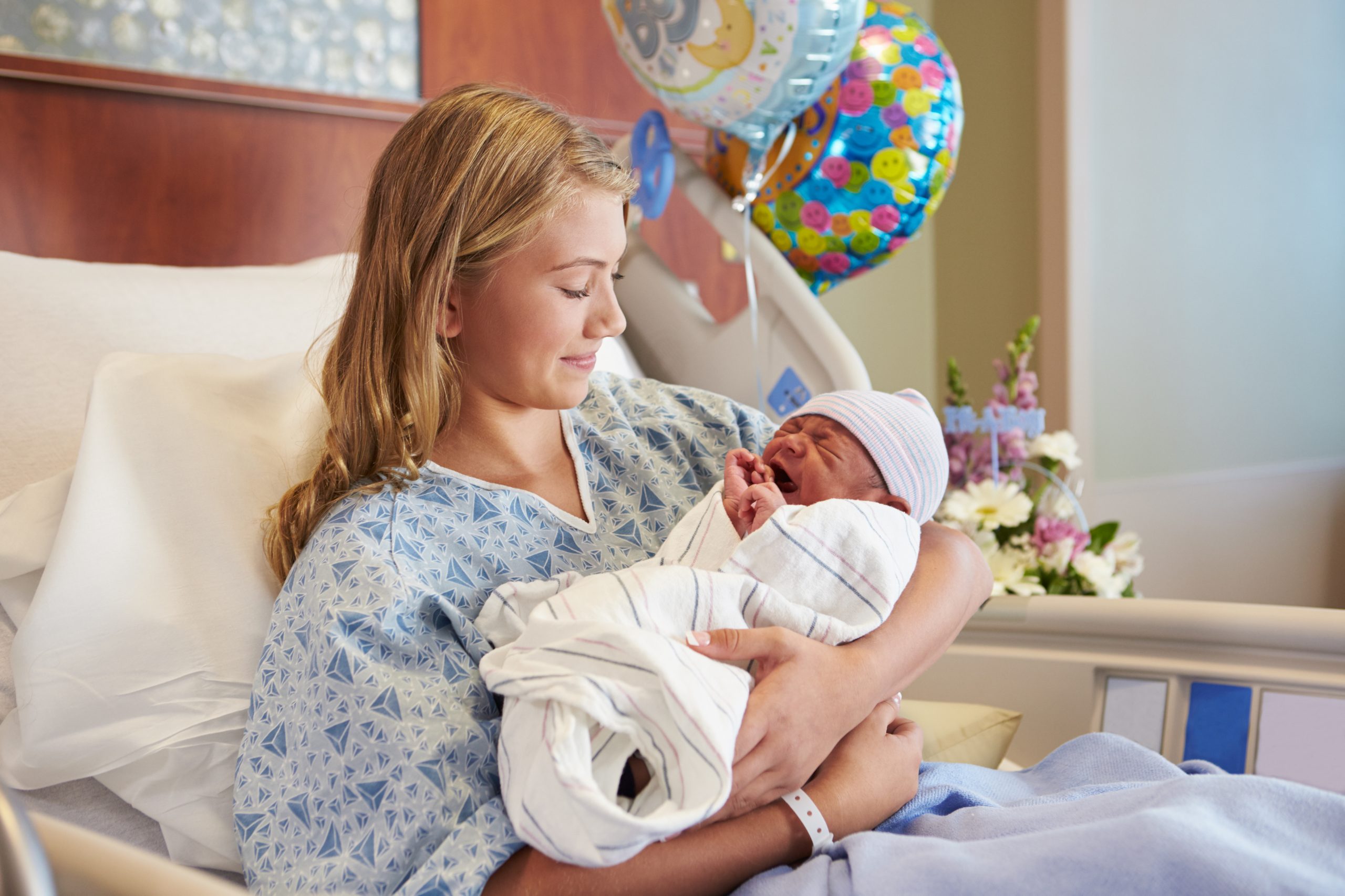 Teenage,Girl,Holding,Newborn,Baby,Son,In,Hospital