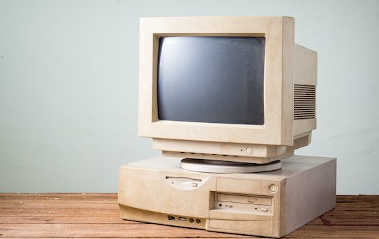 Old,And,Obsolete,Computer,On,Old,Wood,Table,With,Concrete
