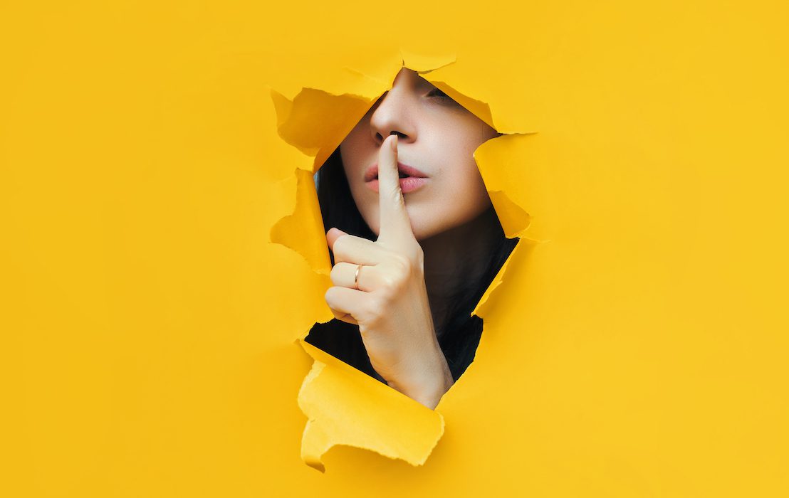 A,Young,Girl,Closes,Her,Lips,With,Her,Index,Finger,making