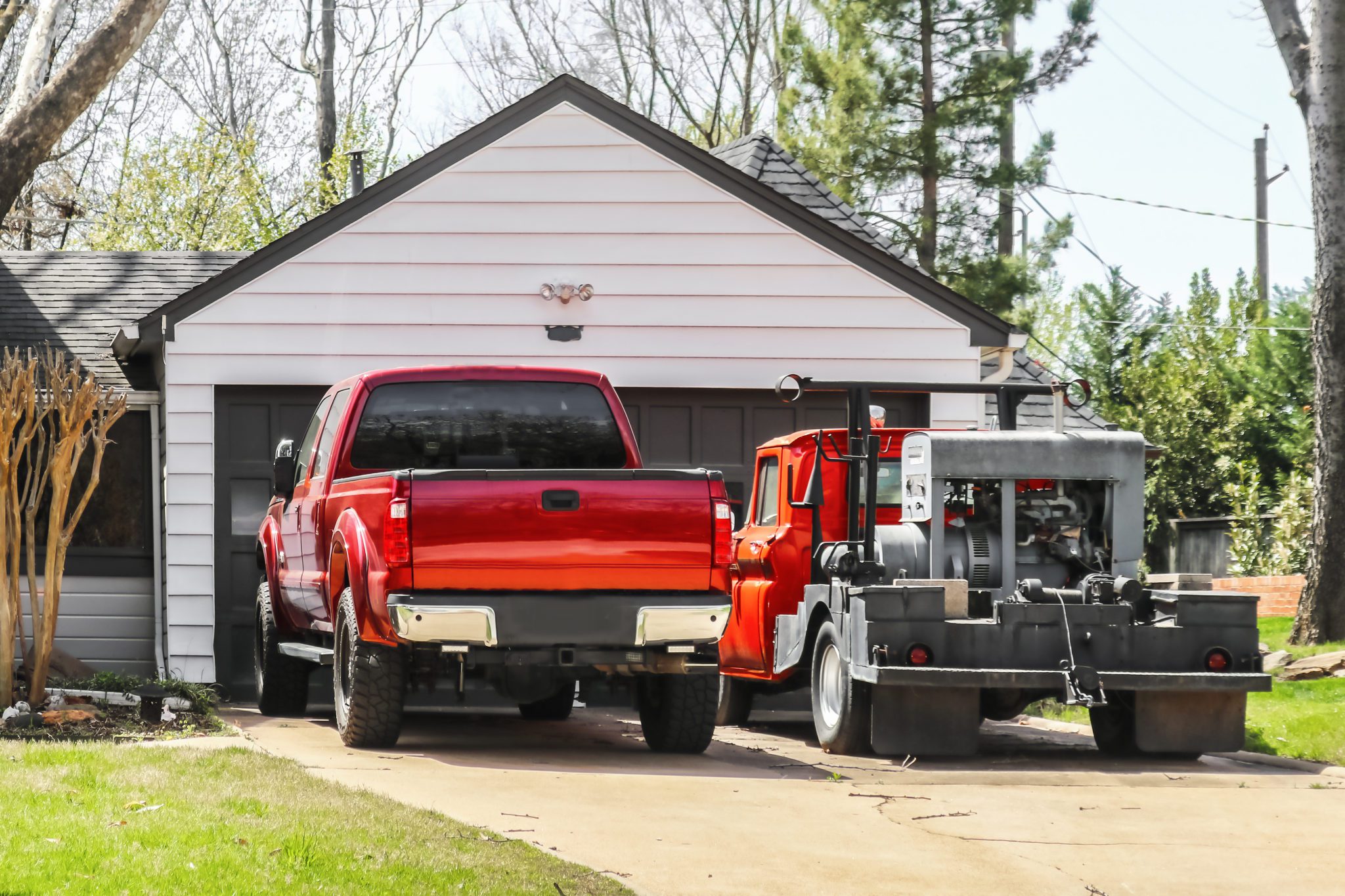 Red,Pickup,Truck,And,Older,Red,Truck,With,Welder,On