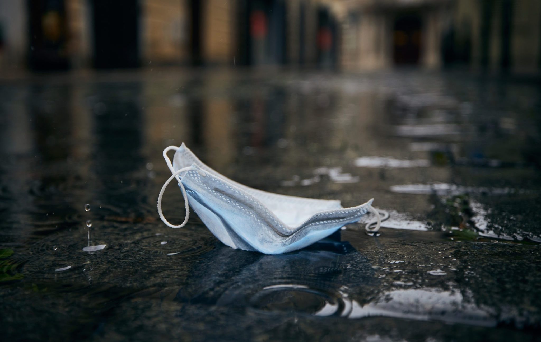 Used,Disposable,Face,Mask,In,Puddle,During,Rain.,Themes,Coronavirus