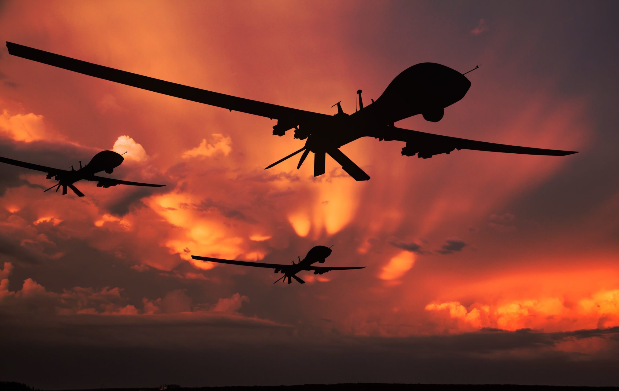 Three,Military,Drones,Silhouettes.,Armed,With,Missiles.,Yellow,Sky,Background.