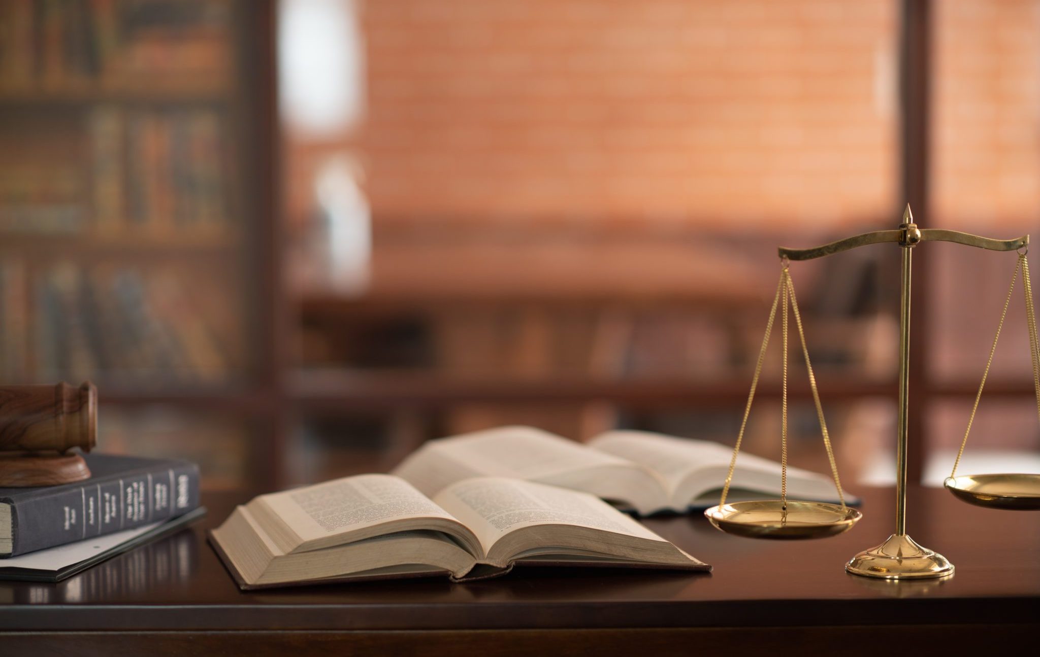 Law,Books,And,Scales,Of,Justice,On,Desk,In,Library