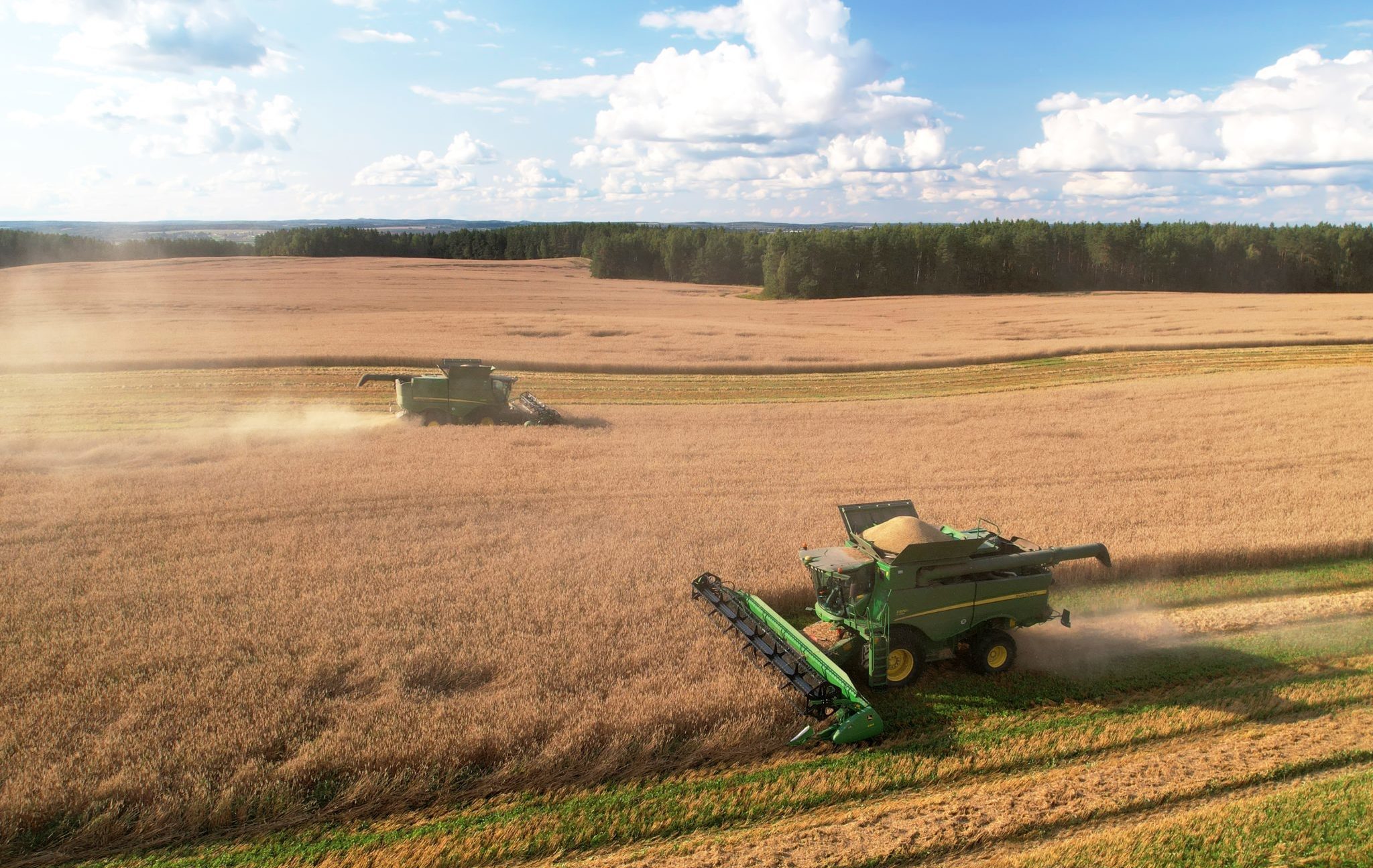 John,Deere,Combine,Harvester,Working,In,Wheat,Field.,Harvest,Season.