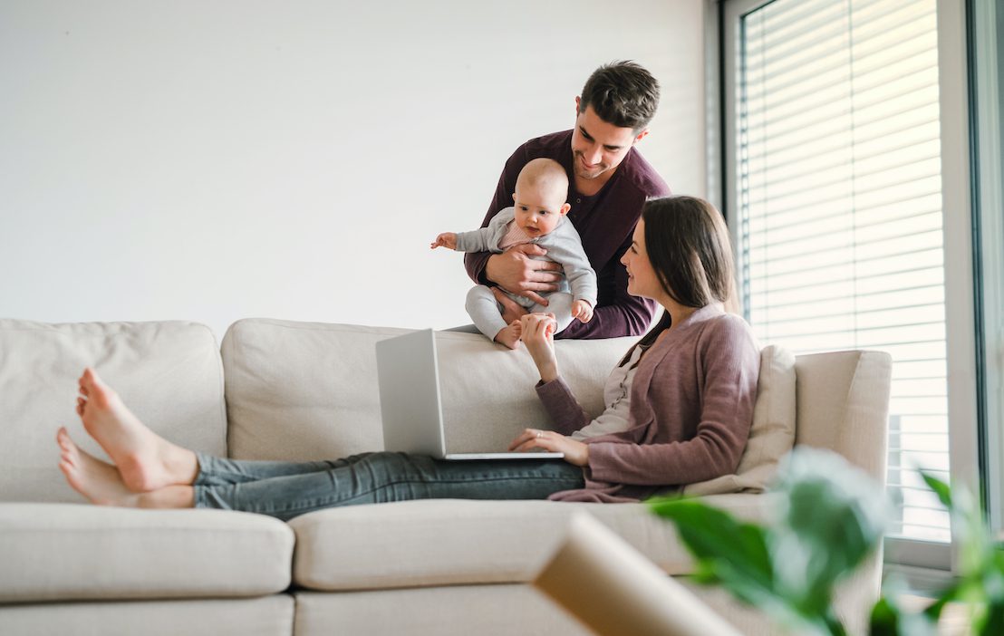 A,Portrait,Of,Young,Couple,With,A,Baby,At,Home,