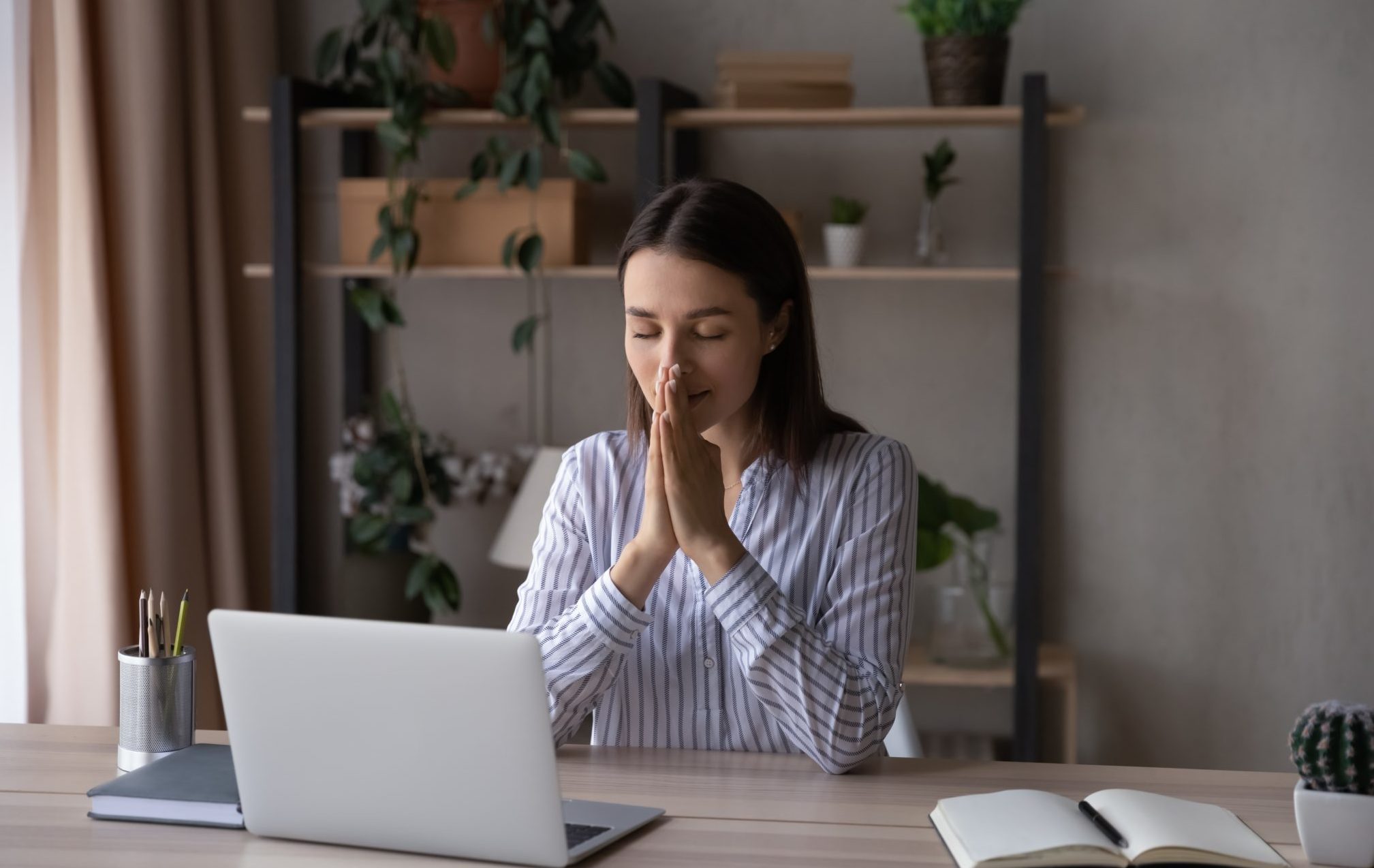 Hopeful,Religious,Businesswoman,Joining,Hands,In,Prayer,,Sitting,At,Home