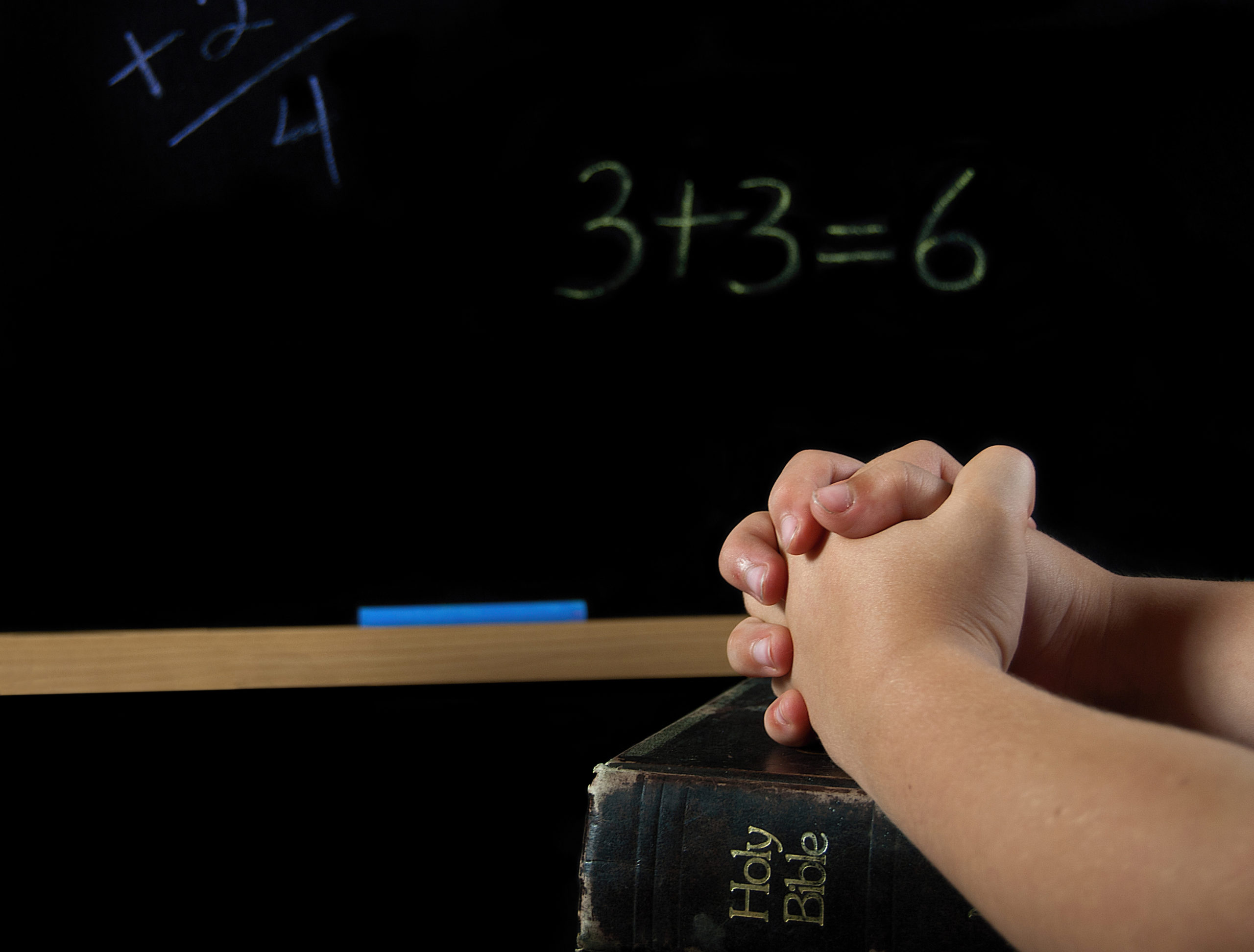 Child's,Hands,Folded,In,Prayer,On,A,Holy,Bible,With