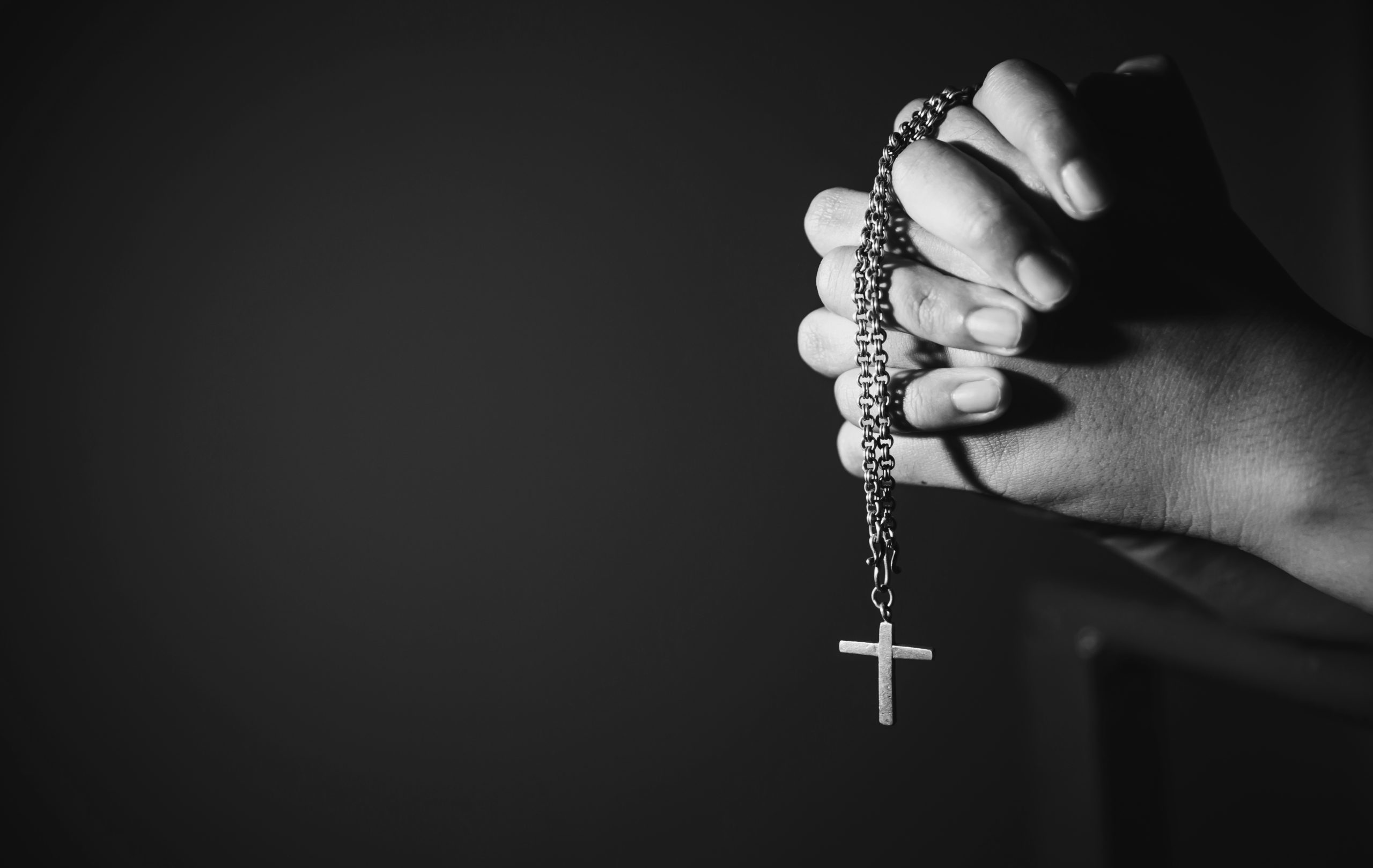 Image,Black,And,White,Woman,Hand,Holding,Rosary,Against,Cross