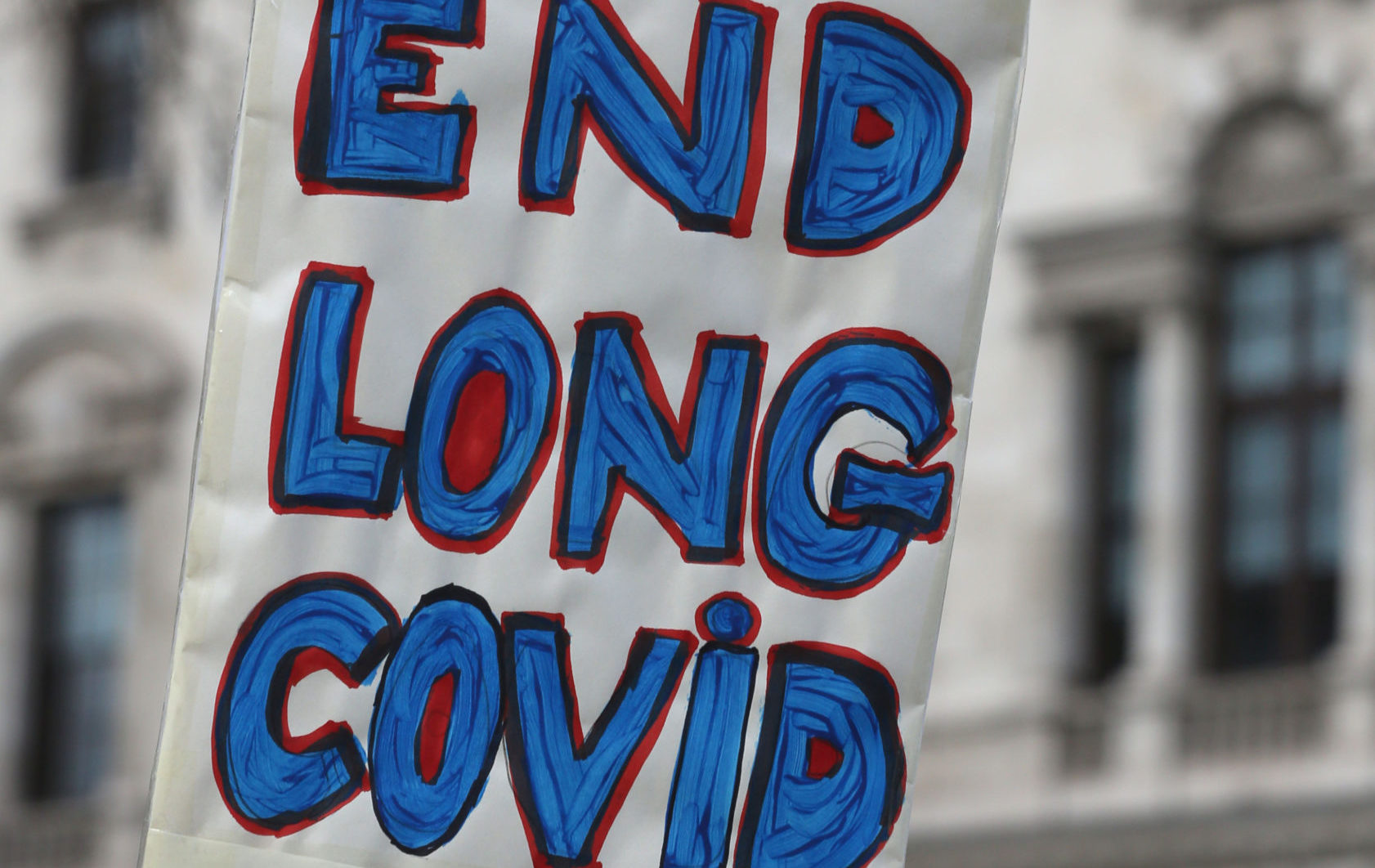 A protester holds up a placard demanding research and an end