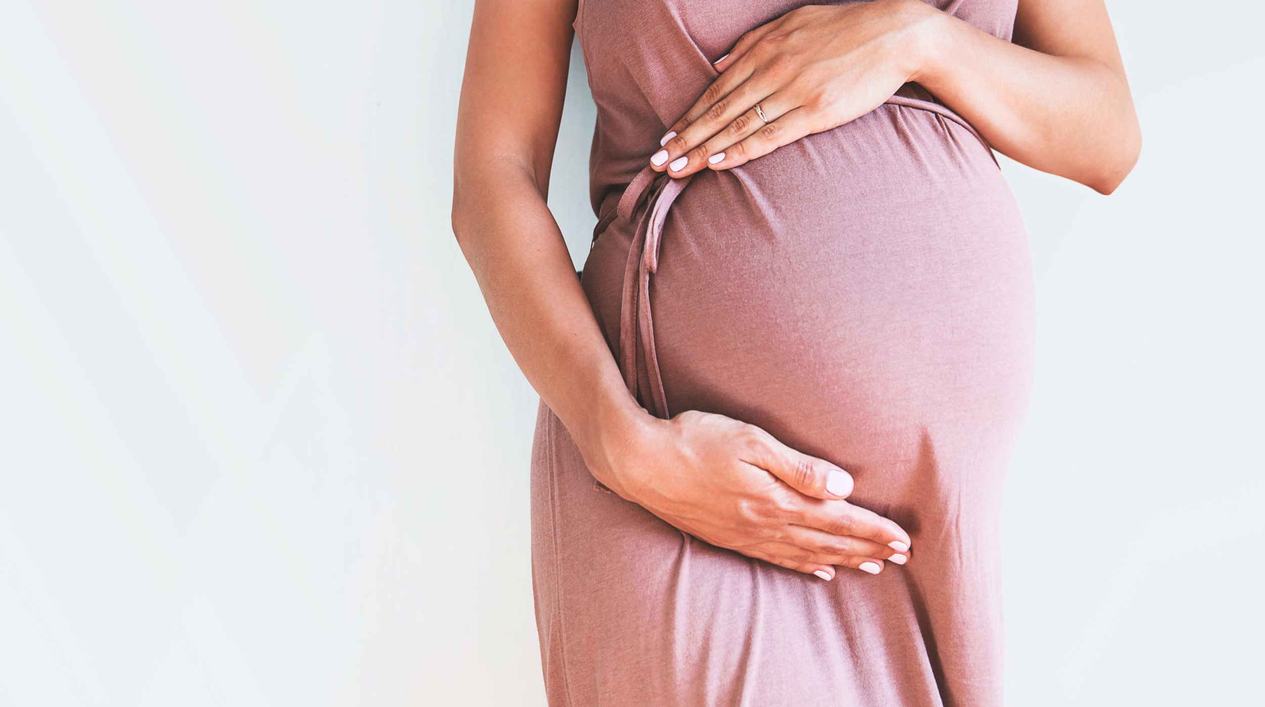 Pregnant,Woman,In,Dress,Holds,Hands,On,Belly,On,A