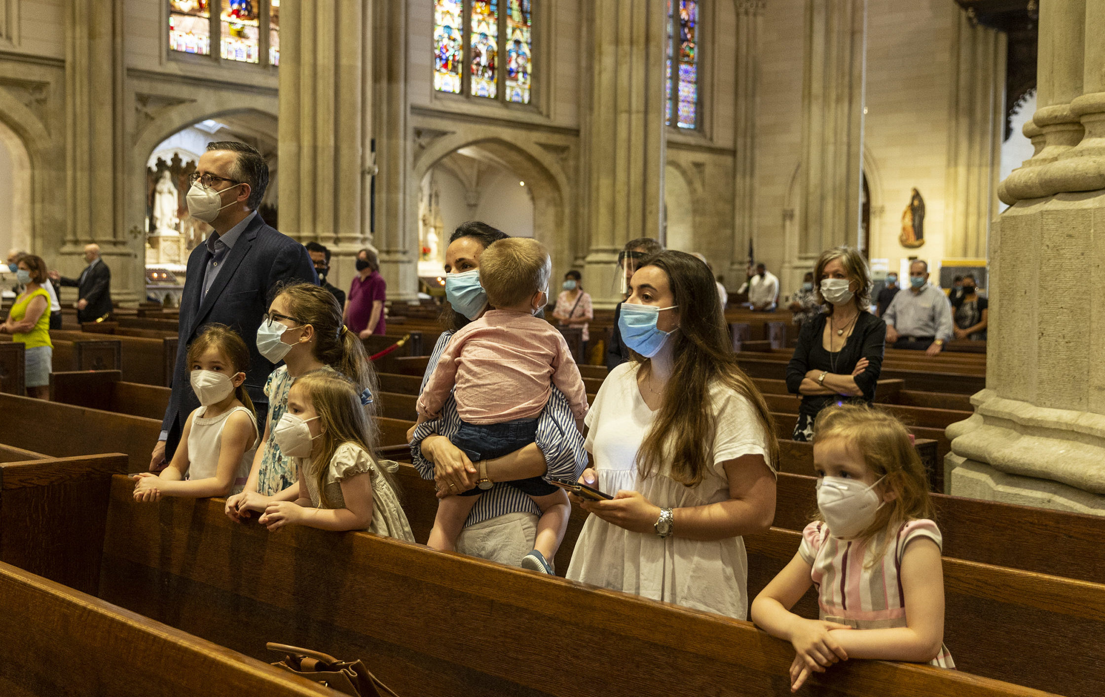A family with kids prays during St. Patrick's Cathedral