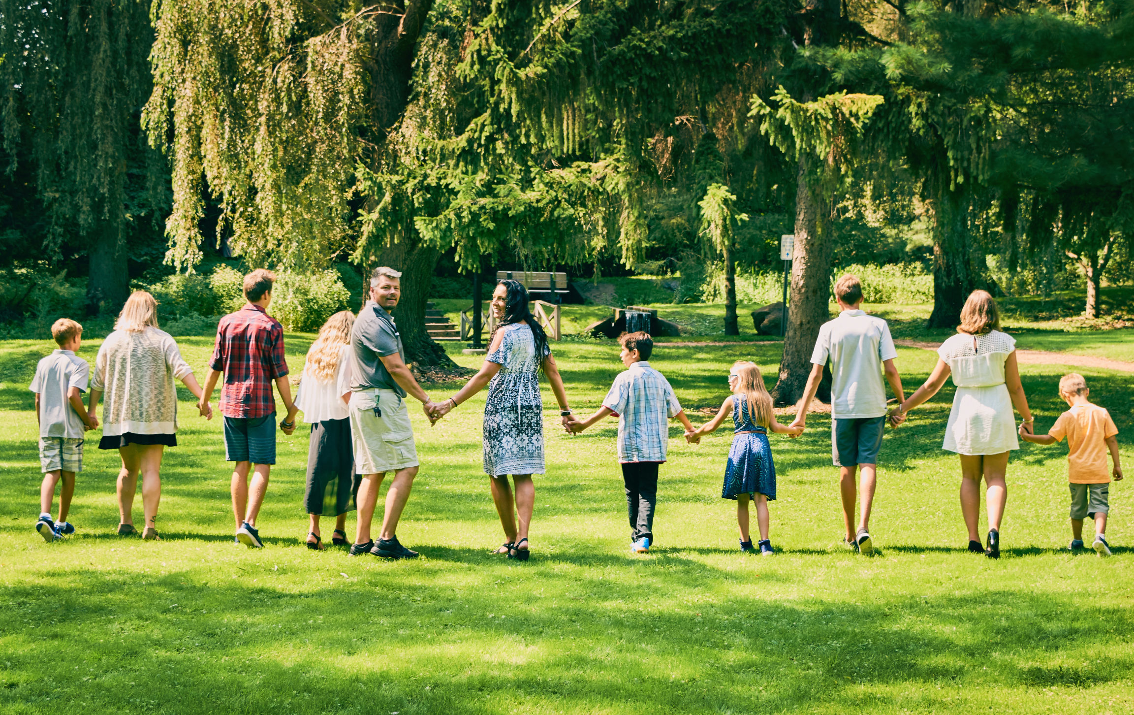 Rear,View,Of,Happy,Couple,Walking,With,Children