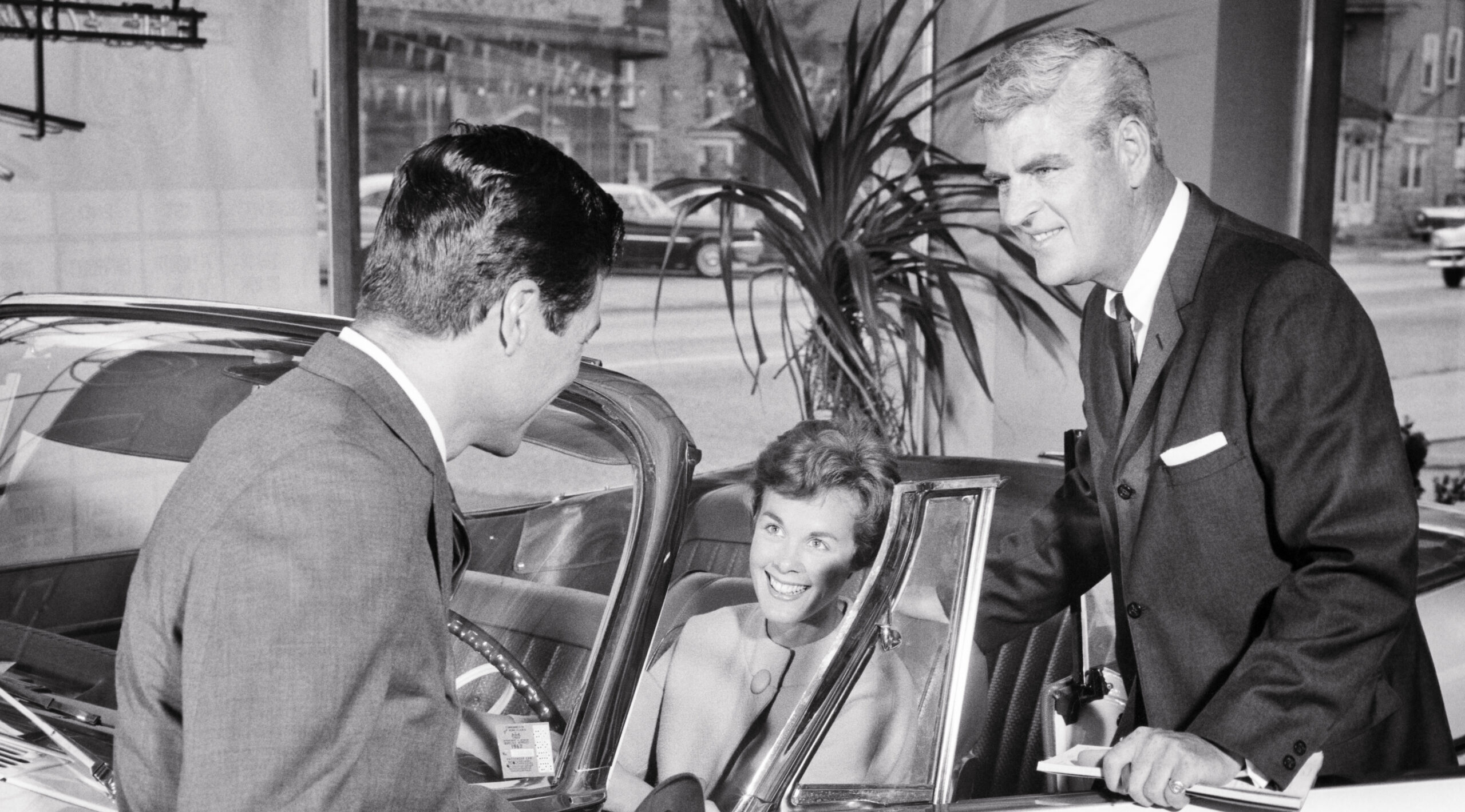 1960s COUPLE BUYING NEW CAR