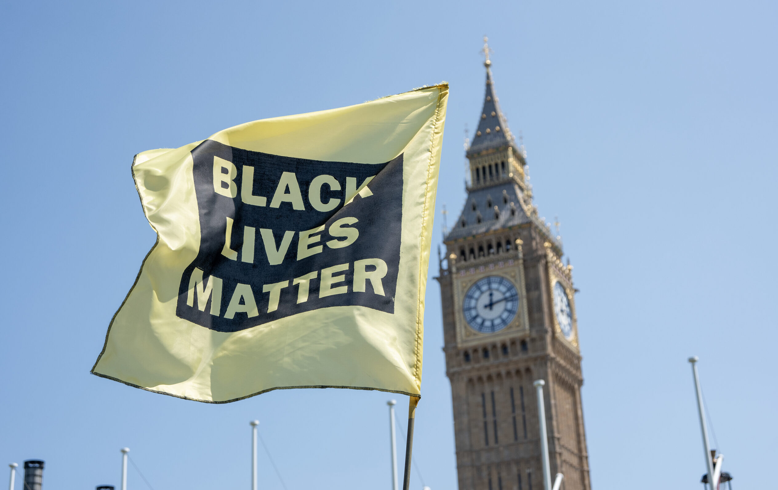 A yellow Black Lives Matter flag waves in front of the Big