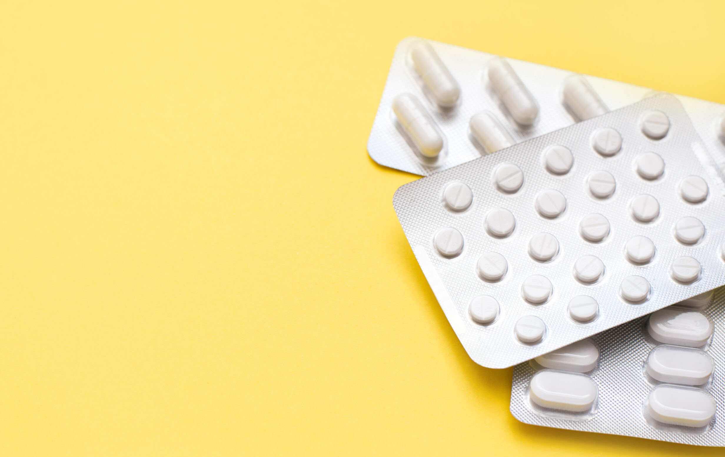 Blisters,With,White,Pills,On,A,Yellow,Spring,Background,With