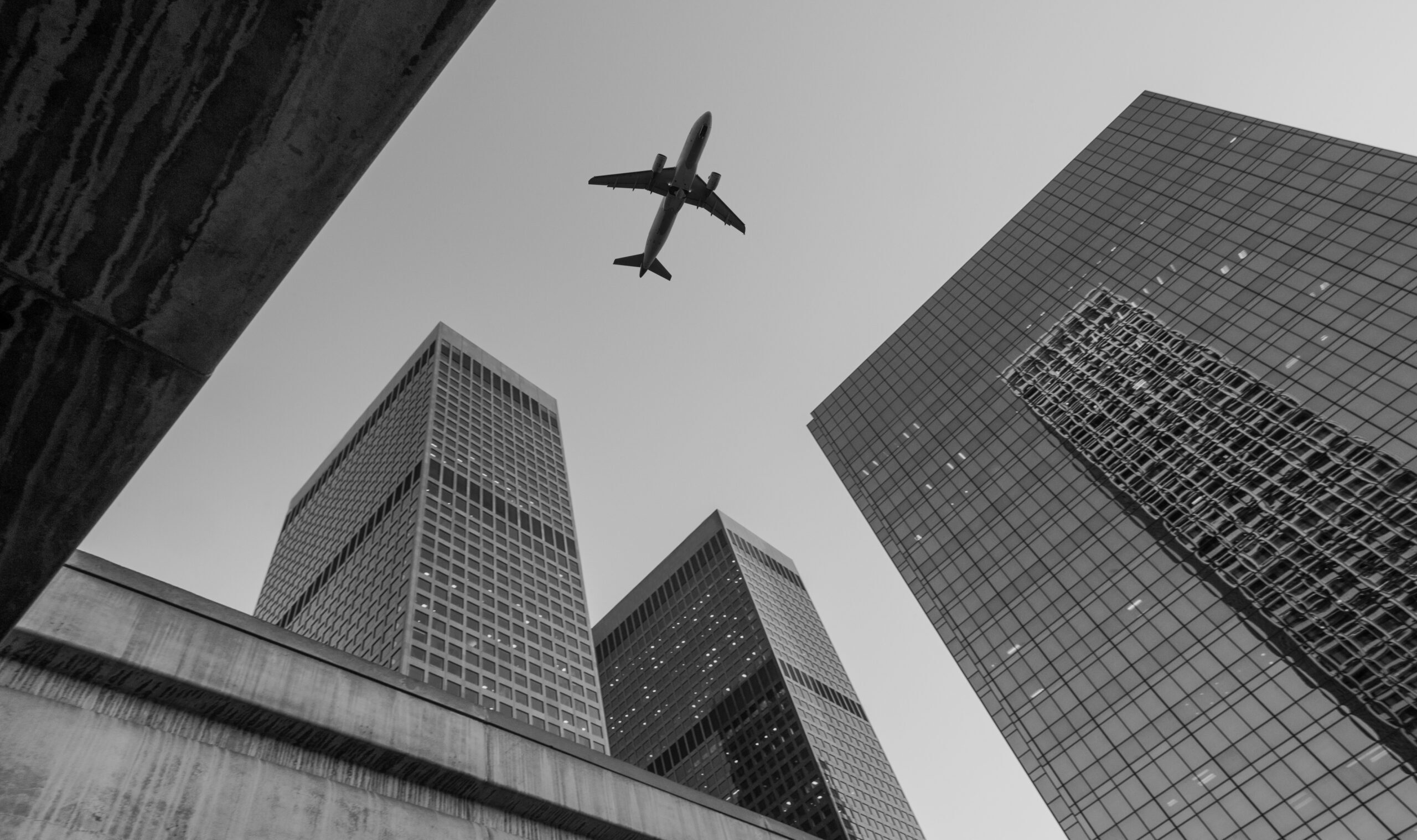 Low,Flying,Commercial,Jet,Aircraft,Passing,Over,City,Skyscrapers