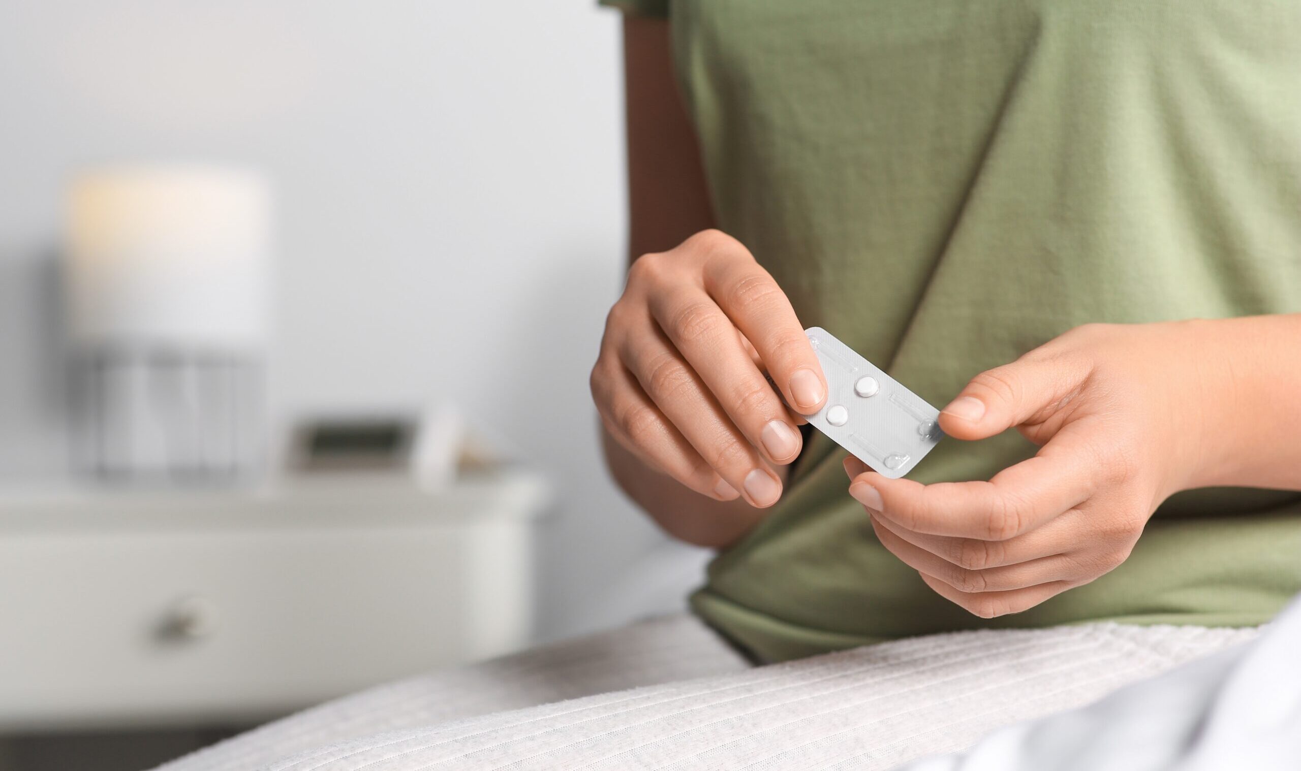 Woman,Holding,Emergency,Contraception,Pills,In,Bedroom,,Focus,On,Hands.