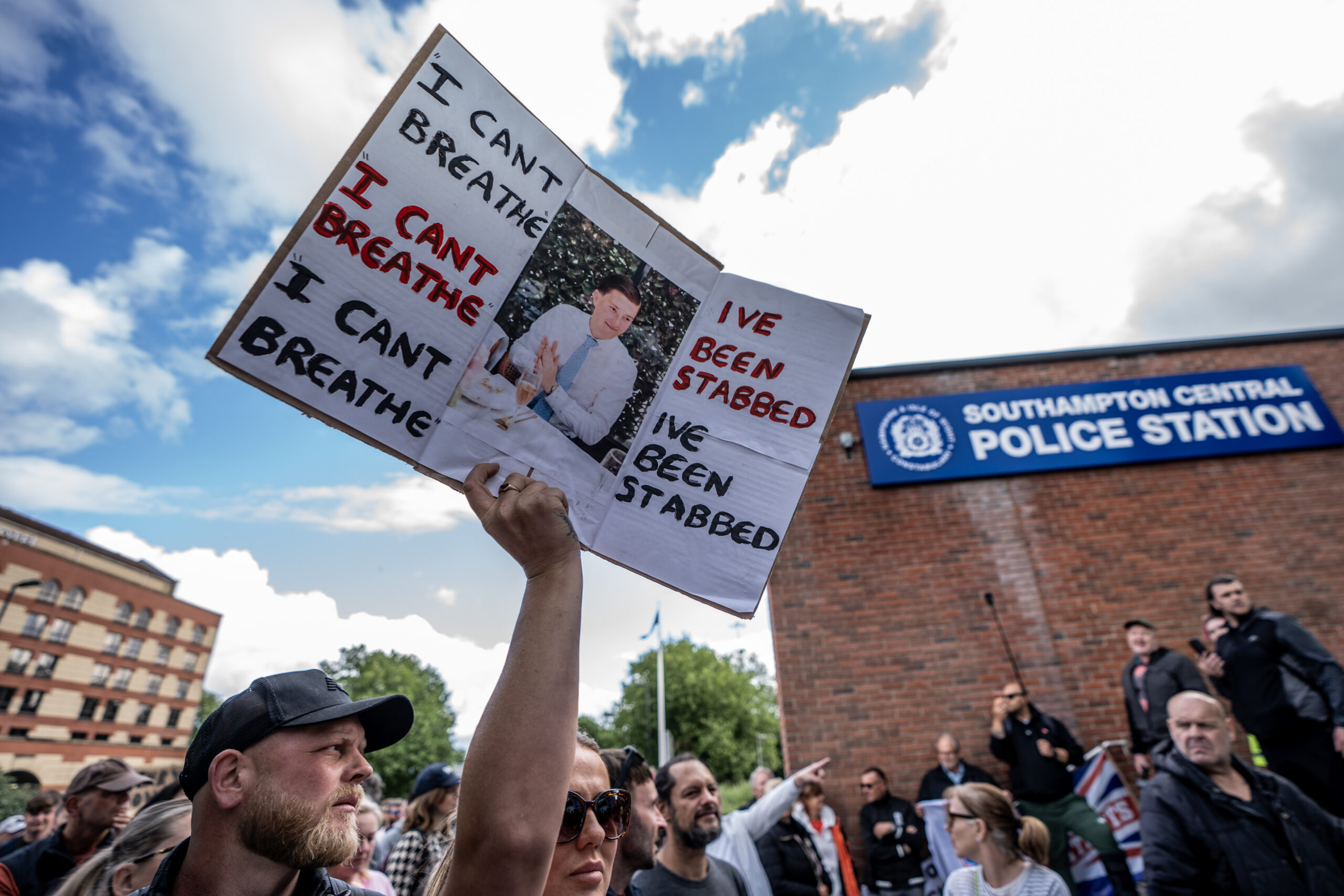 Protestor outside Southampton Central Police Station holds a